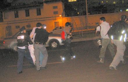 The first arrested protester is dragged to a police car