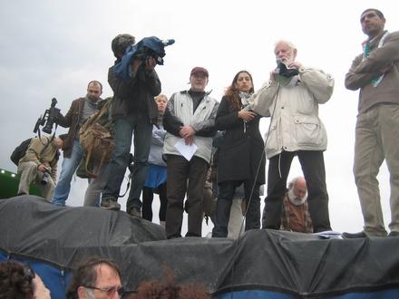 Uri Avnery speaking on top of a truck loaded with flour and sugar sacks