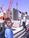 A pupil protesting while a crane puts a concrete slab in its place