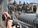 Anarchist Yonatan Pollak climbs over the fence