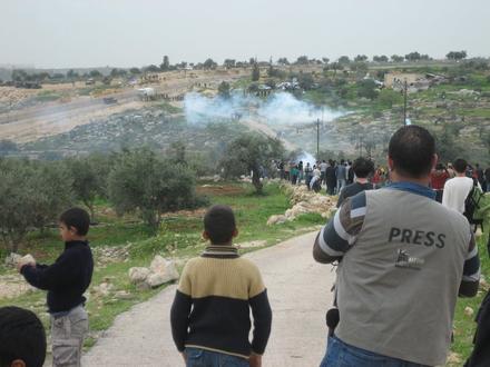 The battlefield from afar: women and children observe the clouds of tear gas all over the ground 