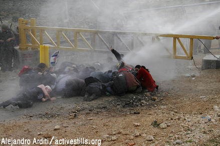 Hiding from the water cannon, Uri Avnery can be recognized among those lying (photo Activestills/awalls.org)