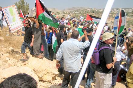 Some of the demonstrators near the fence. One of them carries a map of the West Bank, showing the areas the Israeli government intends to annex